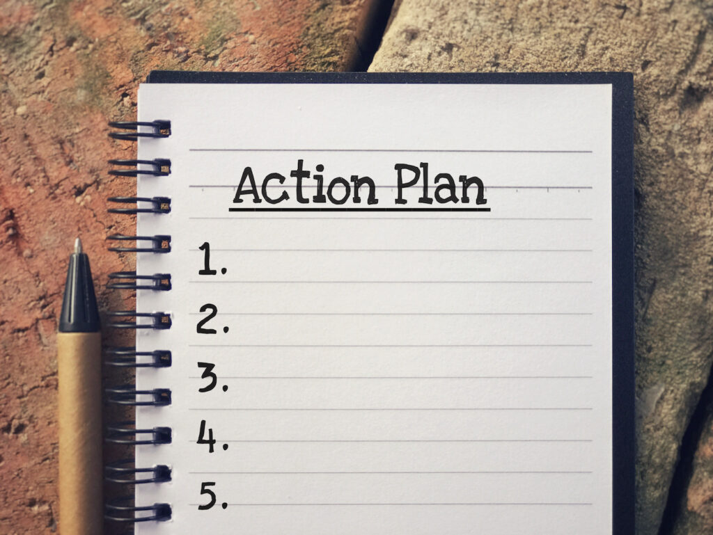 "action plan" written on a notebook with a numbered list below