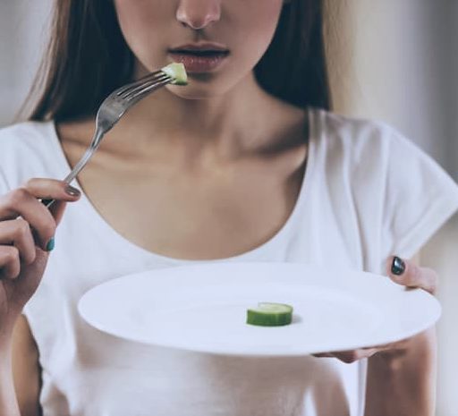 Woman with a slice of cucumber on a plate